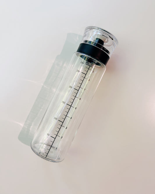 Clear water bottle with black cap on a white background